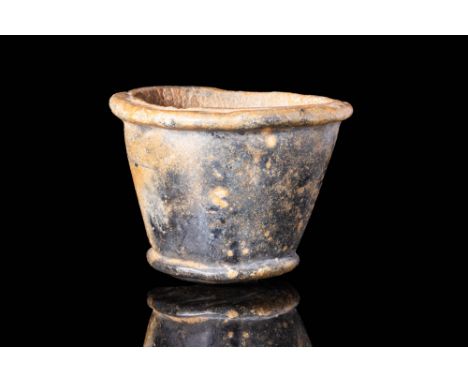 Ca. 1279 - 1213 BC A small stone offering beaker with a flat base, tapering walls and a deep interior cavity. The beaker is d