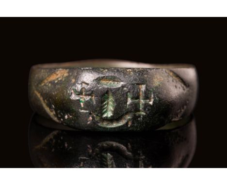 Ca. AD 200 - 400 A Byzantine bronze ring with a bezel depicting a palm branch flanked by two crosses. These symbols are close