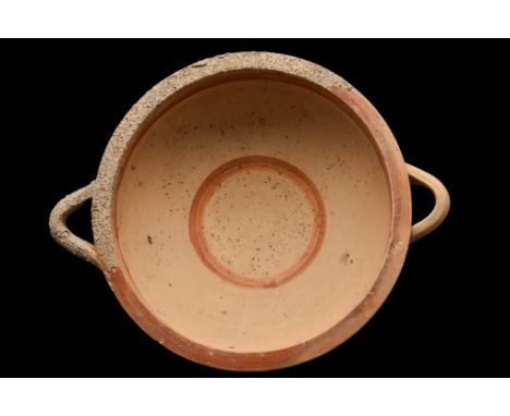 Ca. 700 - 600 BC A pottery dish of a shallow form, resting upon a ring foot and featuring two horizontally oriented handles o