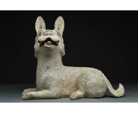 Ca. 202 BC - AD 220 A fine Chinese terracotta dog. The recumubent figure is depicted in the motion of barking, with the mouth