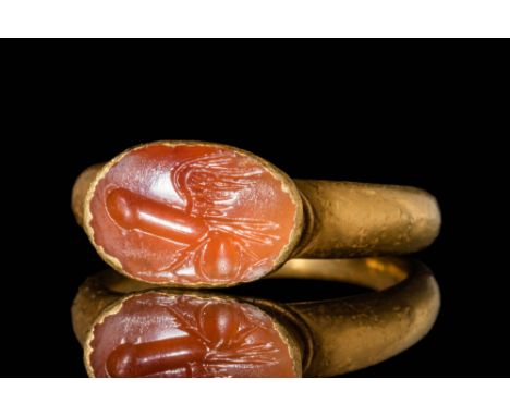 Ca. AD 100 - 300 A Roman gold ring with a carnelian intaglio of a winged phallus depicted in a naturalistic manner. The intag