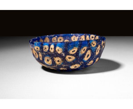 Ca. AD 100 - 300 A Roman mosaic blue glass bowl, made through an intense and difficult process. The deep blue base has been s