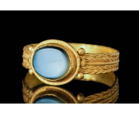 Ca. AD 400 - 600 A magnificent Byzantine gold ring. The ring features a round hoop with a flat section decorated on the exter
