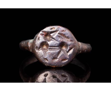Ca. AD 400 - 700 A Merovingian bronze ring featuring a round bezel engraved with a mythological animal, possibly a simplified