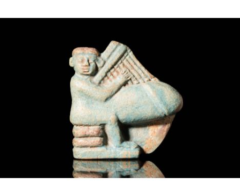 Ca. 664 BC - 332 A bright green faience figure depicting an ithyphallic dwarf sitting on two cushions playing the harp and fa