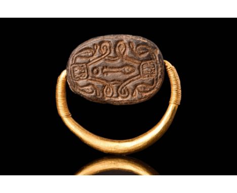 Late Middle Kingdom, Ca. 1850 - 1640 BC A gold ring with a round-section hoop, embellished with coiled gold wire on its finia
