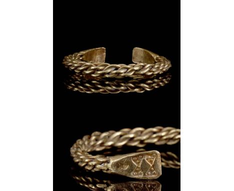 Ca. AD 900 - 1100 A rare penannular gold bracelet, expertly crafted with intertwined strands of gold. The bracelet was made b