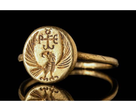 Ca. AD 500 - 700 A Byzantine gold finger ring with a circular hoop connected to a large round bezel. The bezel is engraved wi