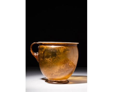 Ca. AD 0 - 200 A free-blown glass cup with a corseted form and an inverted bell-shaped body, a thick round foot, an everted r