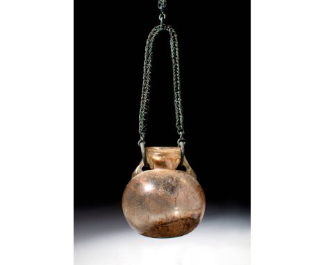 Ca. AD 100 - 300 A Roman mould-blown pale yellow glass amphoriskos, exhibiting a globular form with a slightly concave base. 