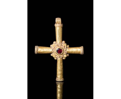 Ca. AD 600 - 700 A Byzantine 23 ct gold cross pendant with a deep red garnet cabochon secured by a gold square bezel. The bez