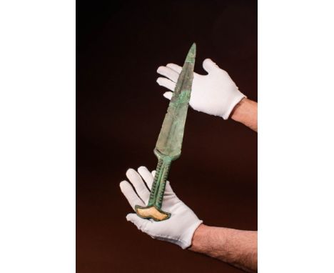 Ca. 800 - 400 BC A bronze dagger featuring a short, double-edged blade adorned with a single ridge that runs down the centre 