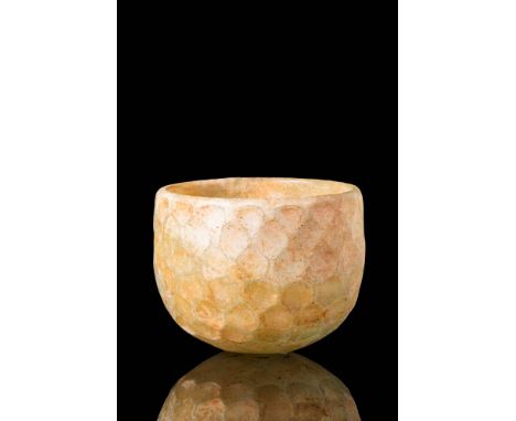 Ca. AD 500 - 700 A charming cup comprised of translucent, slightly yellow glass. It's graceful form with a delicate curved pr