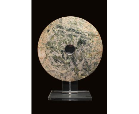 Ca. 3000 BC A Neolithc Liangzhou jade disc of uneven thickness. Its central, circular aperture is cut from both sides, leavin