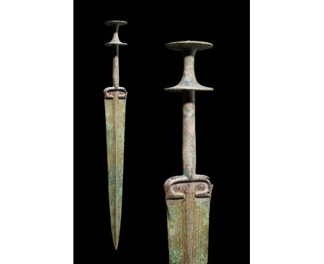 Ca. 1000 - 800 BC An early Bronze Age sword with a long tapering blade featuring a raised mid-rib and a curved decoration on 