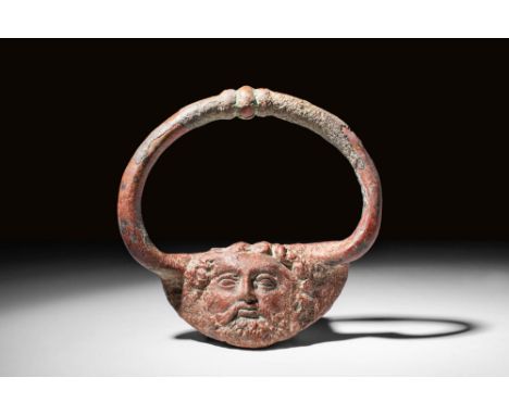 Ca. 400 - 200 BC A Greek cast-bronze handle with two primary components. The handle is comprised of semicircular grip decorat