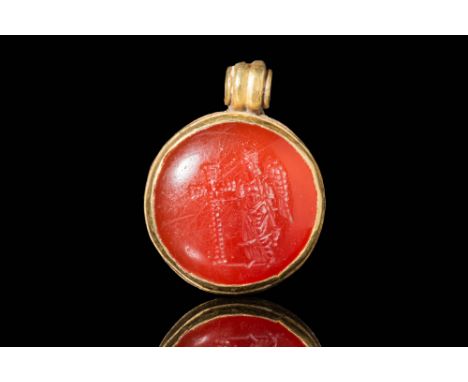 Ca. AD 500 - 600 A Byzantine gold round pendant that secures an amazing carnelian intaglio depicting an angel, facing left in