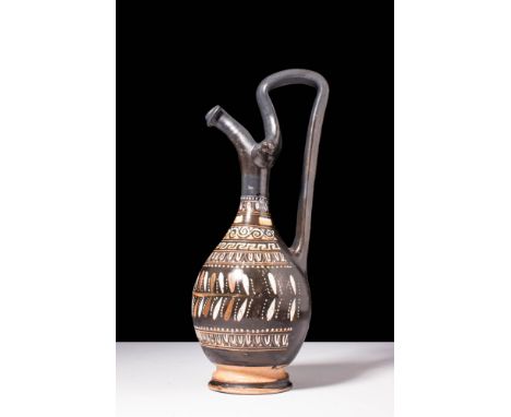 Ca. 330 - 320 BC A Gnathian ware Epichysis with a pear-shaped body and a distinct spool-shaped base. A high, raised handle jo