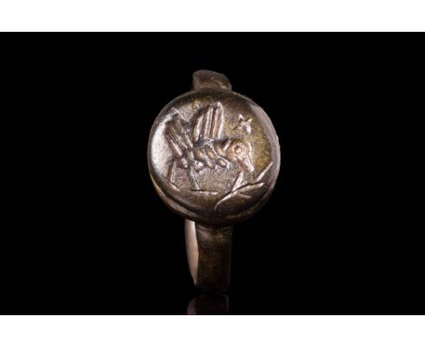 Ca. AD 700 - 1300 A medieval bronze ring with a round bezel. The bezel features an engraving depicting the Holy dove with an 