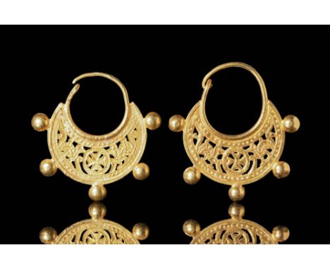 Ca. AD 500 - 700 A matched pair of Byzantine openwork gold earrings with a lunular-shaped body, featuring the Christian symbo