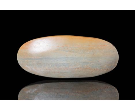 Ca. 5000 - 3000 BC A small polished Neolithic tool made from stone with mottled blue-grey hues. The polished axe head has an 