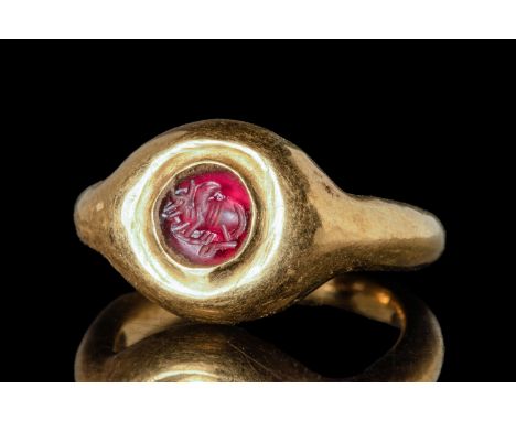 Ca. AD 200 - 400 A Roman gold ring composed of a slender hoop with large shoulders connected to a bezel. This bezel encloses 