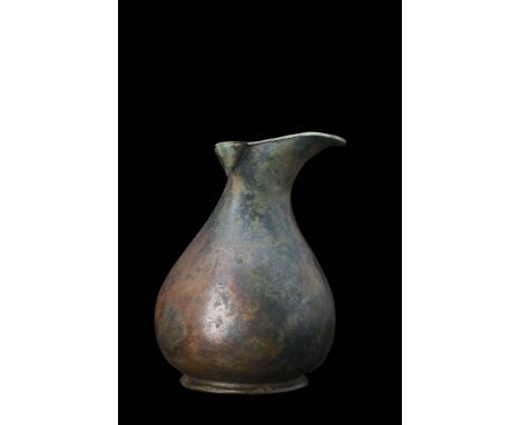 Ca. 1st century AD This bronze oinochoe is elegantly designed with a slender neck and a graceful, bulbous lower body. The tre