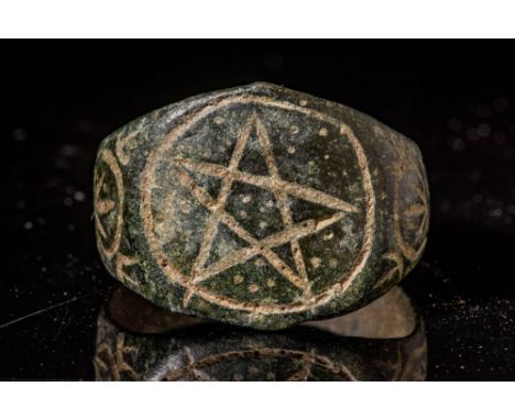 Ca. AD 400 - 500 A late Roman bronze ring boasting a broad, flat-sectioned band expanding to form a bezel. The bezel is engra
