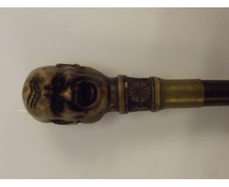 20th century bamboo sword stick, the finial grip modelled as two adorsed contorted faces, much in the style of Franz Xaver Me