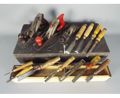 A carpenter's wooden tool case containing a quantity of vintage planes and chisels.