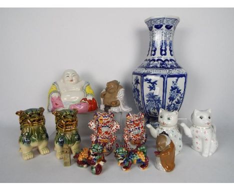 A collection of Oriental ceramics to include octagonal section blue and white vase (36 cm height), Guardian Lions, Budai and 