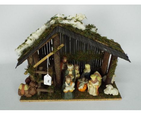 A Christmas Nativity diorama with ceramic figures, approximately 27 cm (h)