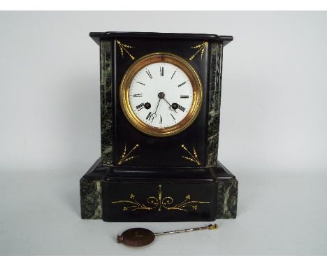 A French black slate and green marble mantel clock with 4" enamel dial having Roman numerals, with pendulum, approximately 25
