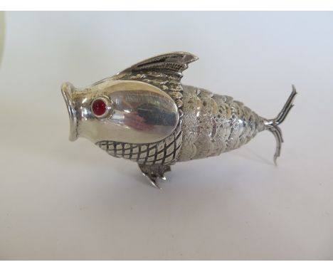 A Spanish silver pepperette in the form of an articulated model of a fish, 915 silver with cabachon red glass eyes, approx we
