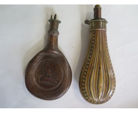 A brass powder flask and a leather powder flask, general usage wear to both 