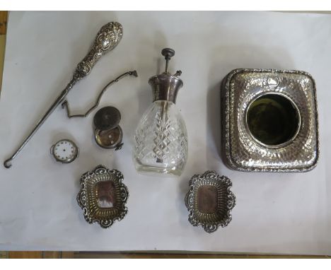 A silver fronted watch holder, two silver watch cases, two silver watch straps, button hook and silver rum scent bottle 