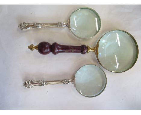 Two silver plated magnifying glasses and another with a mahogany handle - 26cm long 