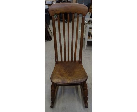 A 19th Century beech and elm rail back Rocking Chair with panel seat and turned supports. 