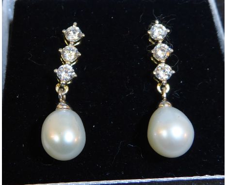 A pair of silver Pendant Earrings set with a pearl and cubic zirconias.