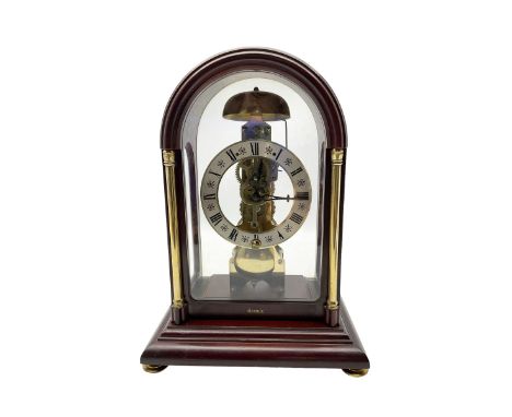 Contemporary Hermle 8-day mantle clock - in a round toped fully glazed case on a rectangular plinth raised on bun feet, skele