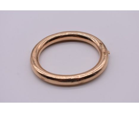 A yellow metal hinged oval bangle,&nbsp;7.2cm wide, 22.5g total weight.