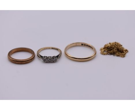 A small group of gold jewellery, comprising: a three stone diamond ring; two wedding bands, hallmarked/stamped 9ct, 6.2g tota
