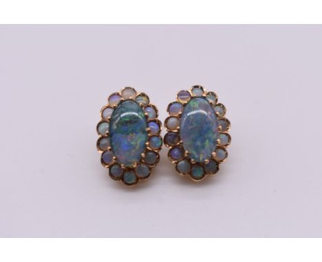 A pair of gold and opal doublet oval ear clips, stamped 575, 17.5mm, 5.8g total weight. 