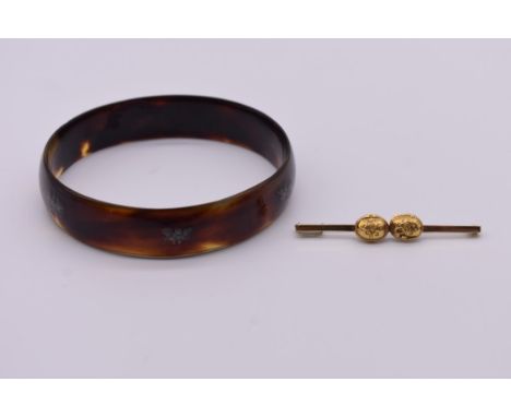 A gold bar brooch, stamped 585, 5cm, 2.9g; together with a tortoiseshell bangle set Chinese characters. (2) 