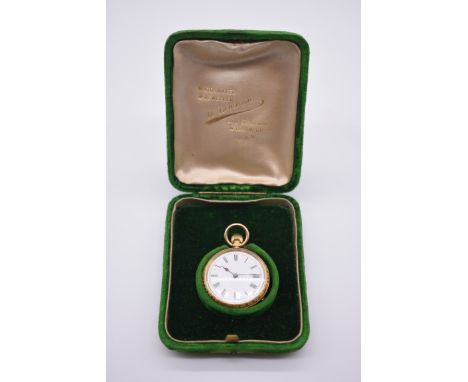 A chased gold stem wind fob watch, stamped 18k, having enamel dial and Roman numerals, 3cm diameter, in fitted case. 
