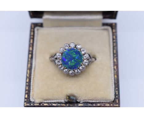 An opal and collet set diamond ring, the unmarked platinum mount having diamond chip shoulders, 4g total weight. Please note 