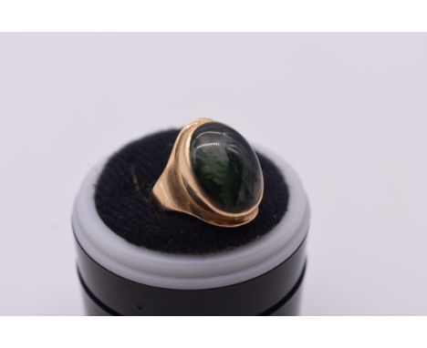 An oval cabochon moss agate gold ring, hallmarked 375, 4.6g total weight. 