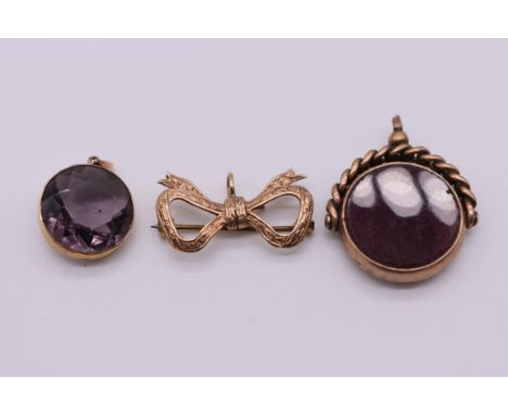 A gold bow fob brooch,&nbsp;2.9cm, 4g; together with a bloodstone and black onyx swivel fob, both hallmarked 375, 10.5g total