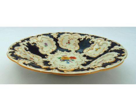 Meissen cobalt blue ground dish circa 1920, decorated with hand painted flowers, leaves and gilding, 29cm (d)