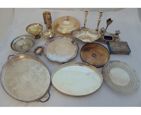 A quantity of silver plate to include a pair of candlesticks, trays, dishes, condiments, cups and a cigarette box